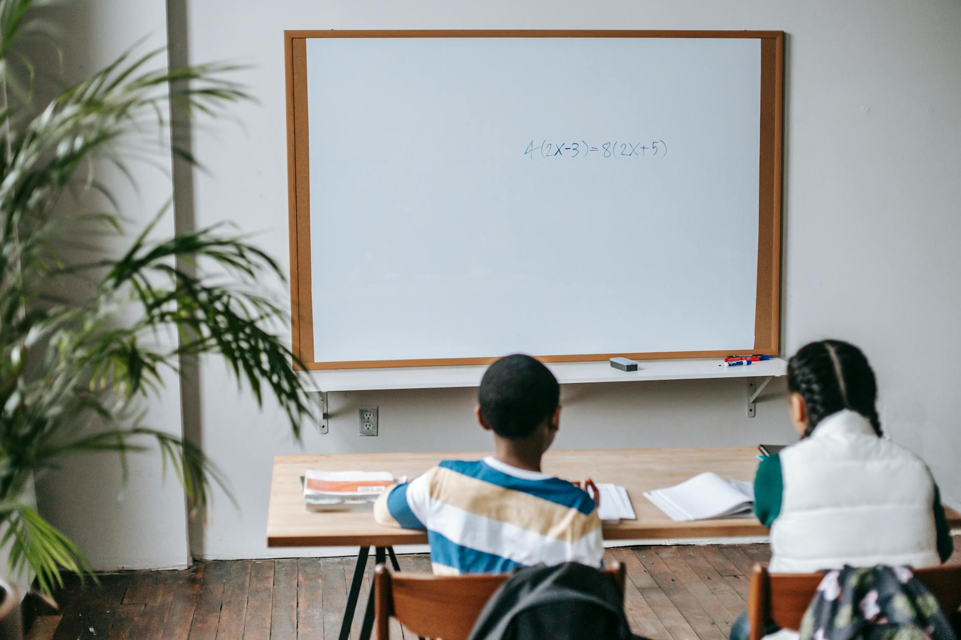 faceless diverse classmates sitting at desk in classroom